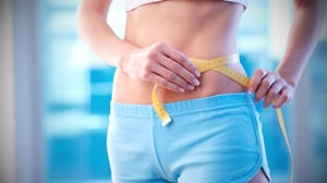 a woman measuring her waistline