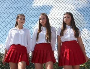 three teenage girls standing outside