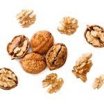 cracking walnuts on white, top view.