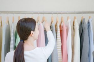 Woman hanging clothes in closet