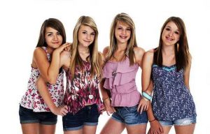 Four teenage girls smiling on white background