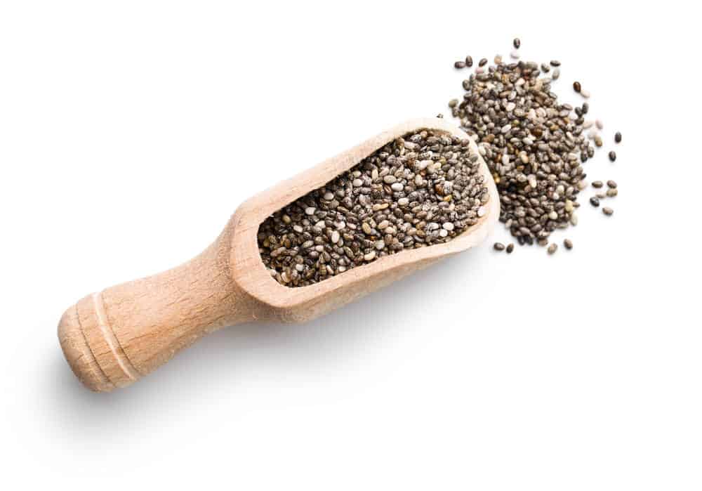 Chia seeds in scoop on white background.