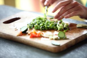 Hands cooking vegetables in kitchen