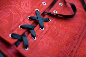 Black lace-up satin ribbon on a red corset
