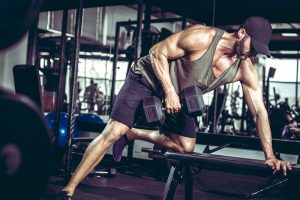 Young man doing one-arm dumbbell rows