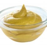 Mustard in glass bowl isolated.