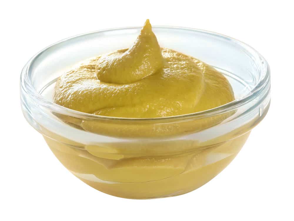 Mustard in glass bowl isolated.
