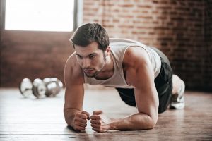 Young man wearing sport wear and doing plank position