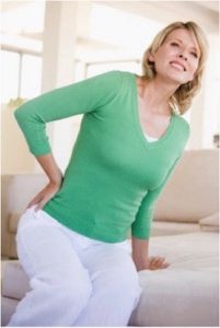 Woman sitting on sofa feeling uncomfortable