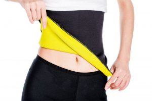 Woman wearing a slimming belt on white background