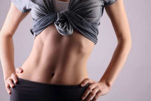 Slim female torso, waist, belly, abdomen close up.