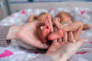 Mother holding premature twins legs